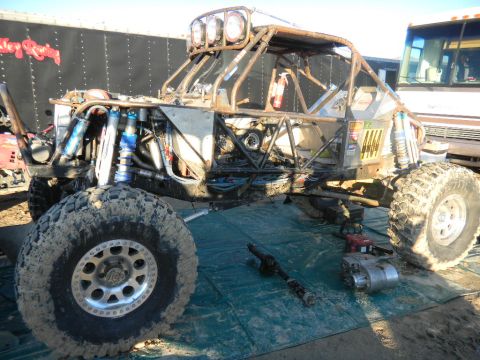 1997 Ford Ranger - Custom buggy with extensive suspension modifications and roll cage, parked on a tarp with spare parts nearby.