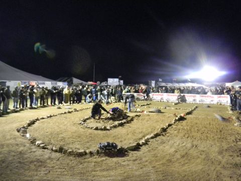 1997 Ford Ranger - Spectators gather to watch remote control cars compete on a custom-built dirt track under bright lights at night.