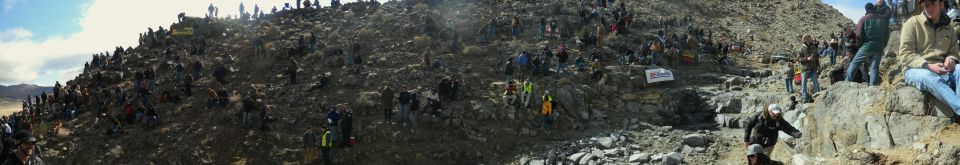 Crowd watching off-road race on rocky hillside