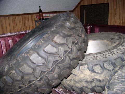 2001 Dodge 1500 - Off-road tires are stored in the cargo area of a pickup truck.