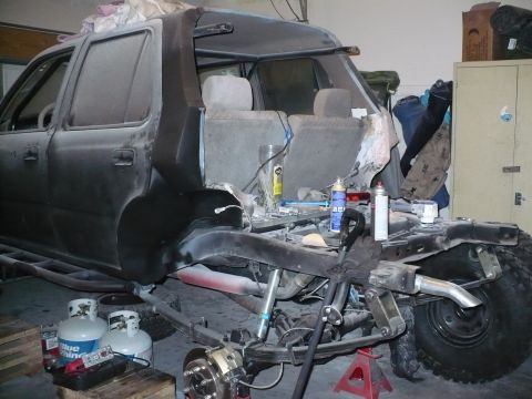 1979 Ford Bronco - This image shows the rear chassis of an SUV in a workshop, with suspension components and exhaust visible, indicating ongoing work.