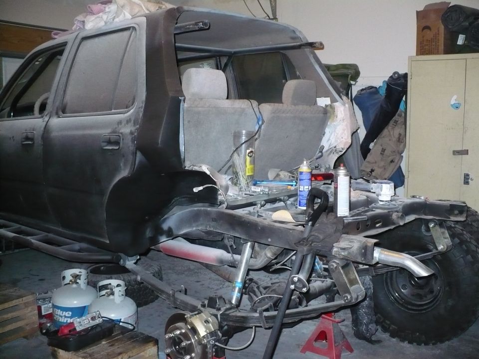 SUV chassis with rear suspension exposed, undergoing modification
