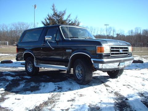 1989 Ford Bronco - This black Ford Bronco, likely a 1987 model, is seen from the front 3/4 angle on a cold, snowy day.