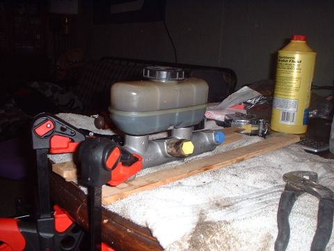 1989 Ford Bronco - A brake master cylinder assembly is shown, with a bottle of synthetic brake fluid nearby.