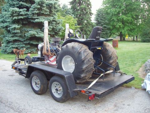 1972 Ford Ranchero - Modified tractor puller with oversized tires and dual exhaust pipes loaded onto a trailer.