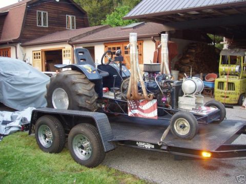 1972 Ford Ranchero - A custom tractor puller, a V8 engine and prominent exhaust stacks, is loaded onto a trailer.