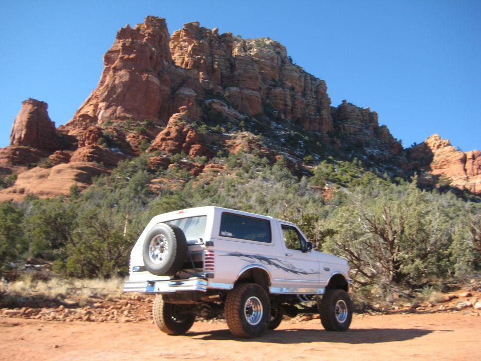 1996 Ford Bronco parked on dirt road with red rock formations in background