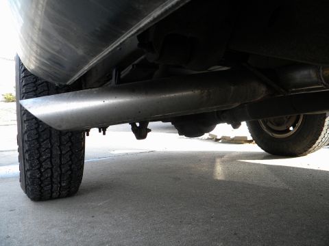 1995 GMC Sierra 1500 - The exhaust system and rear wheel are visible from a low angle beneath the vehicle.