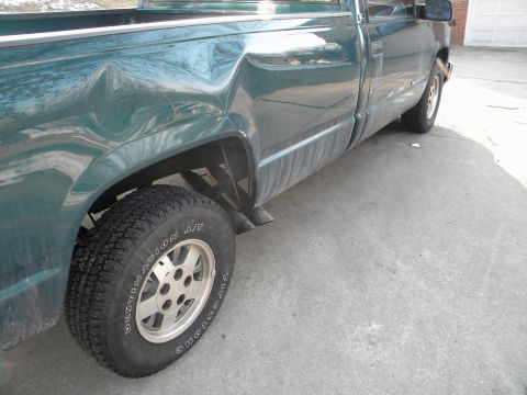 1995 GMC Sierra 1500 - This 1995 GMC Sierra 1500 pickup truck shows extensive damage to its rear quarter panel.