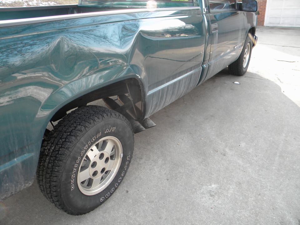 Green 1995 GMC Sierra 1500 pickup truck with significant rear quarter panel damage