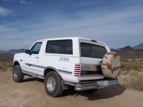 1996 Ford Bronco - White 1996 Ford Bronco with FX4 decal and camouflage spare tire cover in a desert landscape.