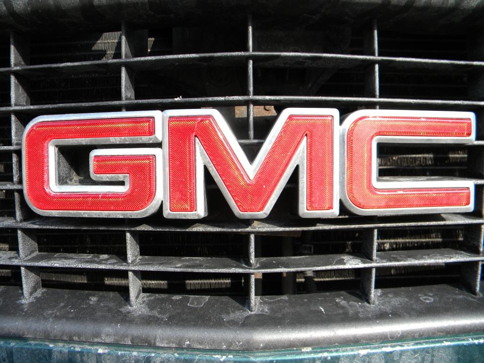 Red GMC emblem on a black grille. 1995 GMC Sierra 1500