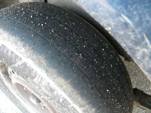 1993 Dodge Grand Caravan - This tire shows significant wear and has small stones stuck in the tread grooves.