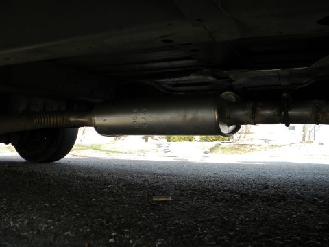 1993 Dodge Grand Caravan - The exhaust system of a vehicle is shown from underneath, with markings on the muffler.