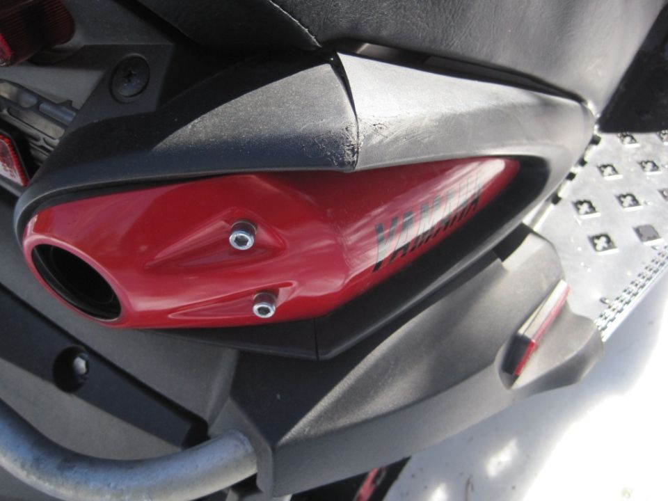 Red Yamaha snowmobile side panel with black bodywork and aluminum running board