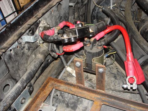 1992 Ford Bronco - Close-up view of the engine bay wiring and battery components, including a starter solenoid and fuse block.