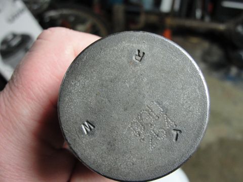 1995 Ford Bronco - A person holds a metal component with stamped letters and numbers, possibly a vehicle part.