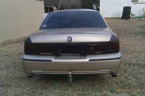 2000 Mercury Grand Marquis - Rear view of a gold 2000 Mercury Grand Marquis sedan parked outdoors.