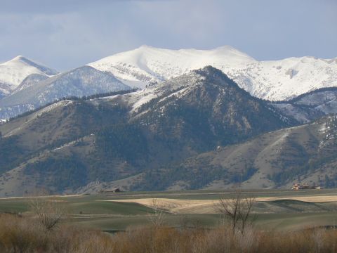 2006 Ford E350 - A vast landscape snow-capped peaks and green hills under a cloudy sky.