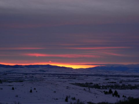2006 Ford E350 - Winter sunset over a snow-covered valley with mountains on the horizon.