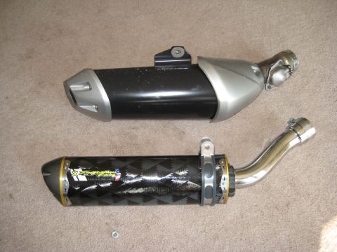 2008 Yamaha FZR1000 - Two aftermarket motorcycle exhaust mufflers are shown side-by-side on a carpeted surface.