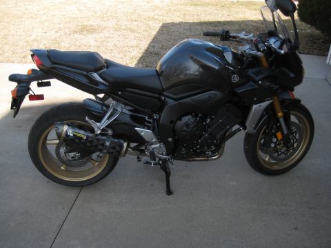 2008 Yamaha FZR1000 - A black Yamaha motorcycle is parked on a concrete surface with a grassy area in the background.