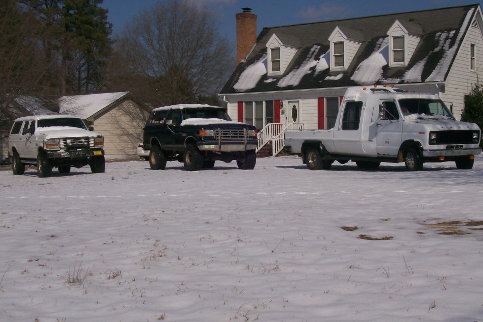 Black Ford Bronco with lifted suspension in snow, front view