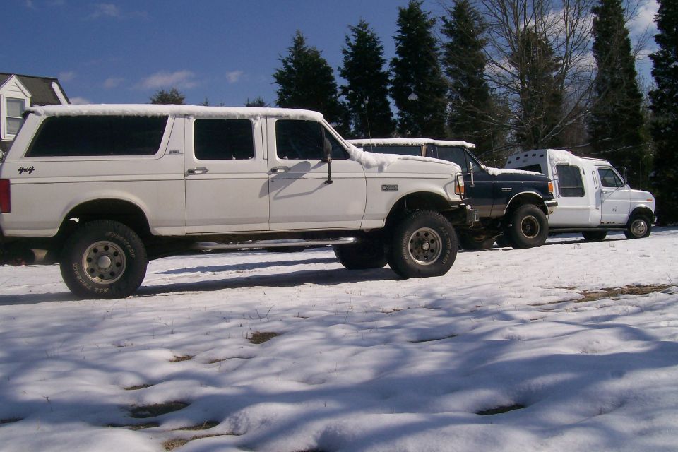 White 1992 Ford Bronco SUV parked in snow next to other vehicles