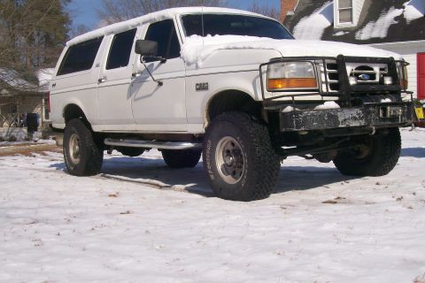 1992 Ford C-350 (Centurion Conversions) - This lifted white SUV is parked in a snowy area, with snow covering its roof and hood.