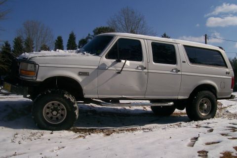 1992 Ford C-350 (Centurion Conversions) - This lifted 1992 Ford F-250 extended cab pickup truck is equipped with a camper shell and large off-road tires.