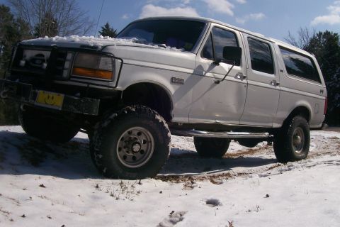 1992 Ford C-350 (Centurion Conversions) - This white extended cab pickup truck is seen in a snowy environment with an aftermarket bumper and large tires.