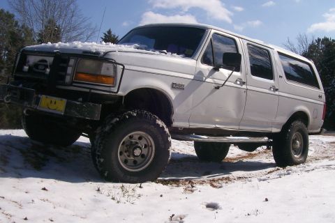 1992 Ford C-350 (Centurion Conversions) - White 1992 Ford C-350 (Centurion Conversions) with large tires sits in a snowy landscape.