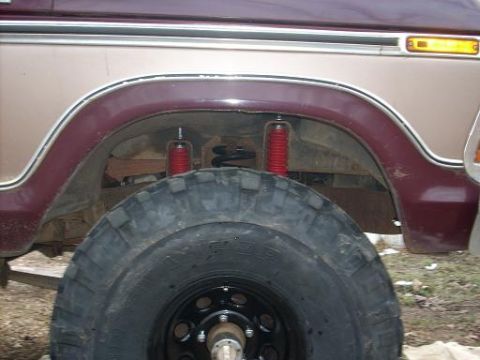 1979 Ford Bronco - This photo shows the rear wheel well of a Ford Bronco, with a prominent tire and suspension components visible.