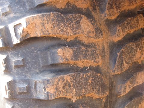 1995 Ford Bronco - This is a close-up view of a tire tread with mud caked in the grooves.