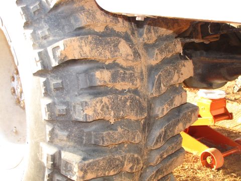 1995 Ford Bronco - Close-up of a heavily used off-road tire and vehicle undercarriage, suggesting off-road activity.