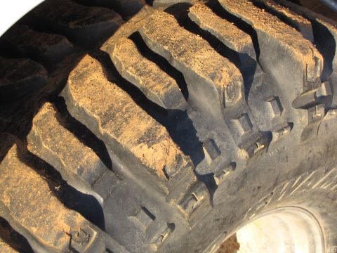 1995 Ford Bronco - Muddy off-road tire tread detail.
