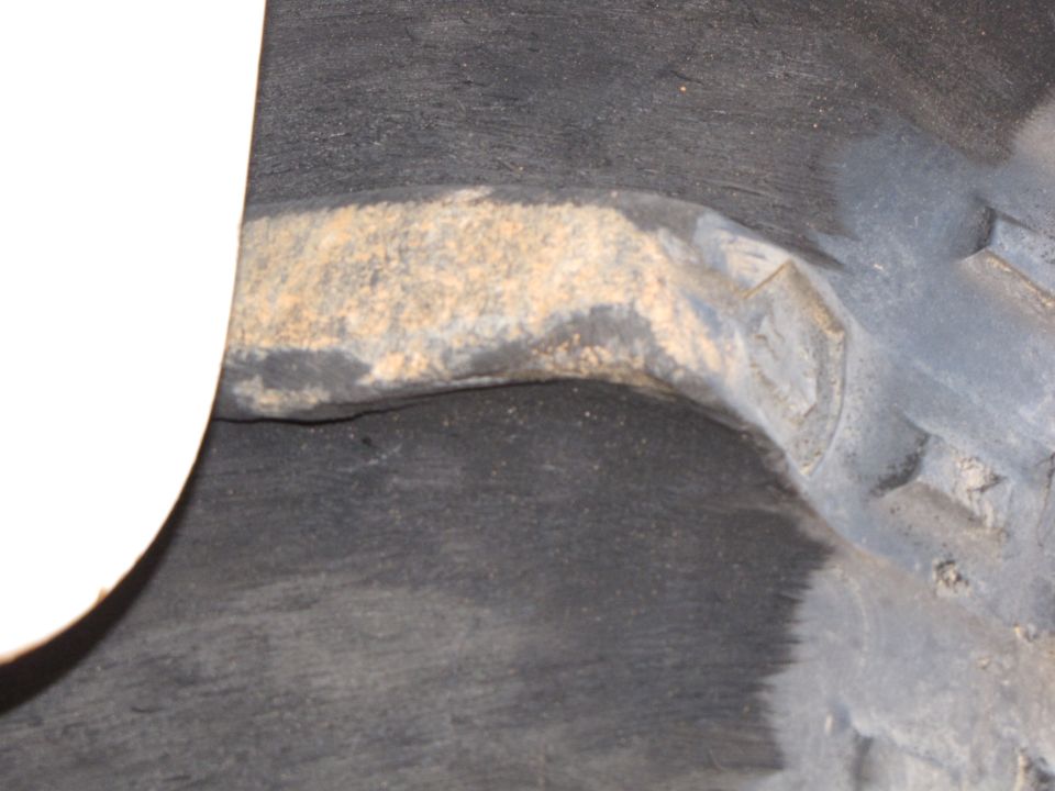 close-up of a rusty suspension part in a wheel well
