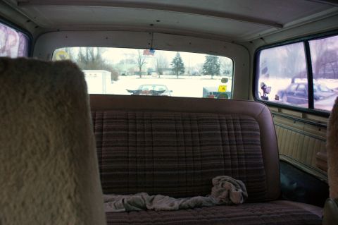 1979 Ford Bronco - View from the back seat of a 1979 Ford Bronco, showing the interior and a snowy landscape with other vehicles outside.