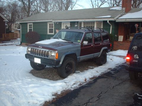 1989 Ford Bronco - A two-tone Jeep Cherokee XJ sits in the snow, with another Jeep visible to the right.