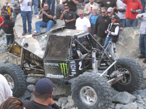 1986 Ford Bronco - A custom off-road buggy with sponsorship logos navigates a challenging rocky course.