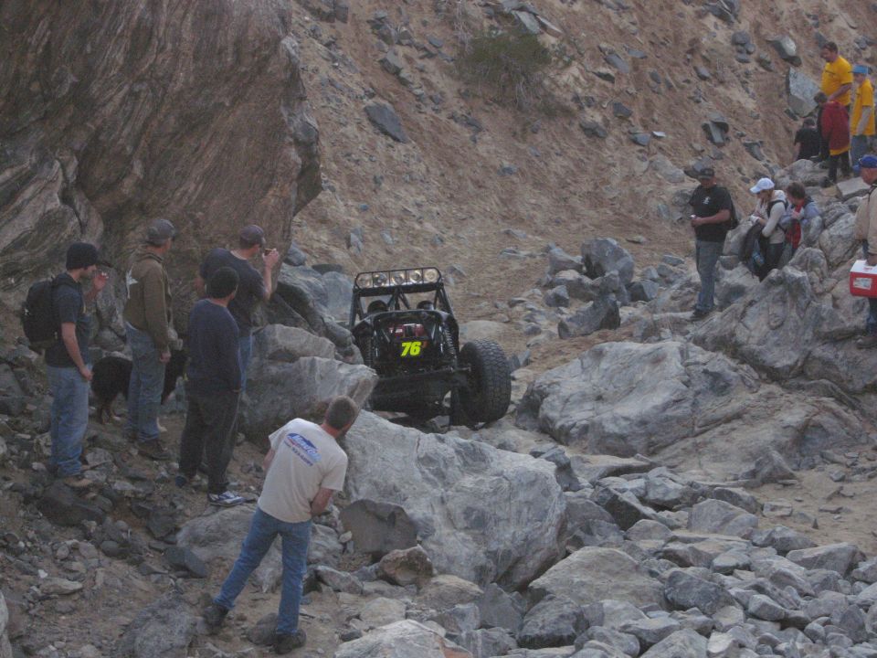 Off-road buggy with number 76 navigating rocky terrain