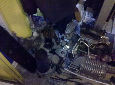 1992 Ford Bronco - Various engine components, including a supercharger, are piled on the floor, suggesting a project or disassembled vehicle.