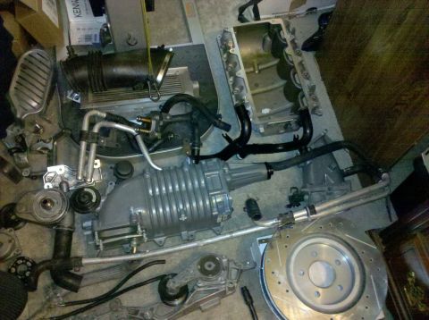 1992 Ford Bronco - Various engine parts, including a supercharger and intake manifold, are spread across the floor.