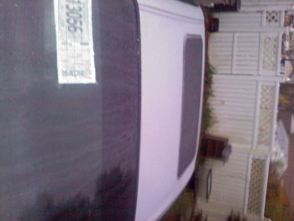 White vehicle side view with a license plate showing 13056