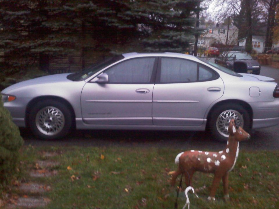 Silver 2000 Pontiac Grand Prix sedan, side view. Another car is parked in the background