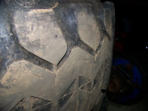 2001 Dodge 1500 - Close-up of a tire tread with visible wear and mud. The background is dark and indistinct.