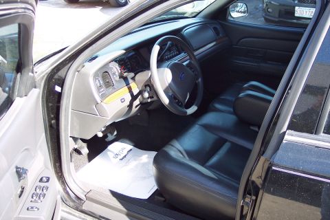 2001 Ford Crown Victoria - The interior of a black 2001 Ford Crown Victoria is shown, leather seats and the dashboard.