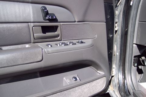 2001 Ford Crown Victoria - Interior door panel of a 2001 Ford Crown Victoria, showing the power window and seat controls.