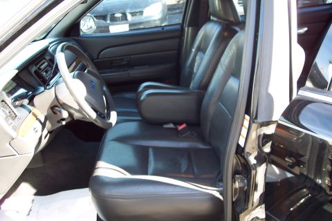 2001 Ford Crown Victoria - Interior view of a 2001 Ford Crown Victoria, likely a police vehicle, with black leather seats.