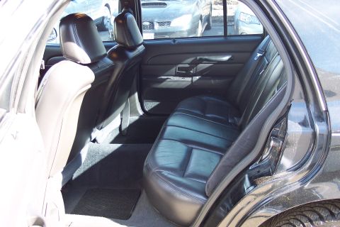 2001 Ford Crown Victoria - The interior of a black sedan is shown, with other vehicles visible through the rear windows.